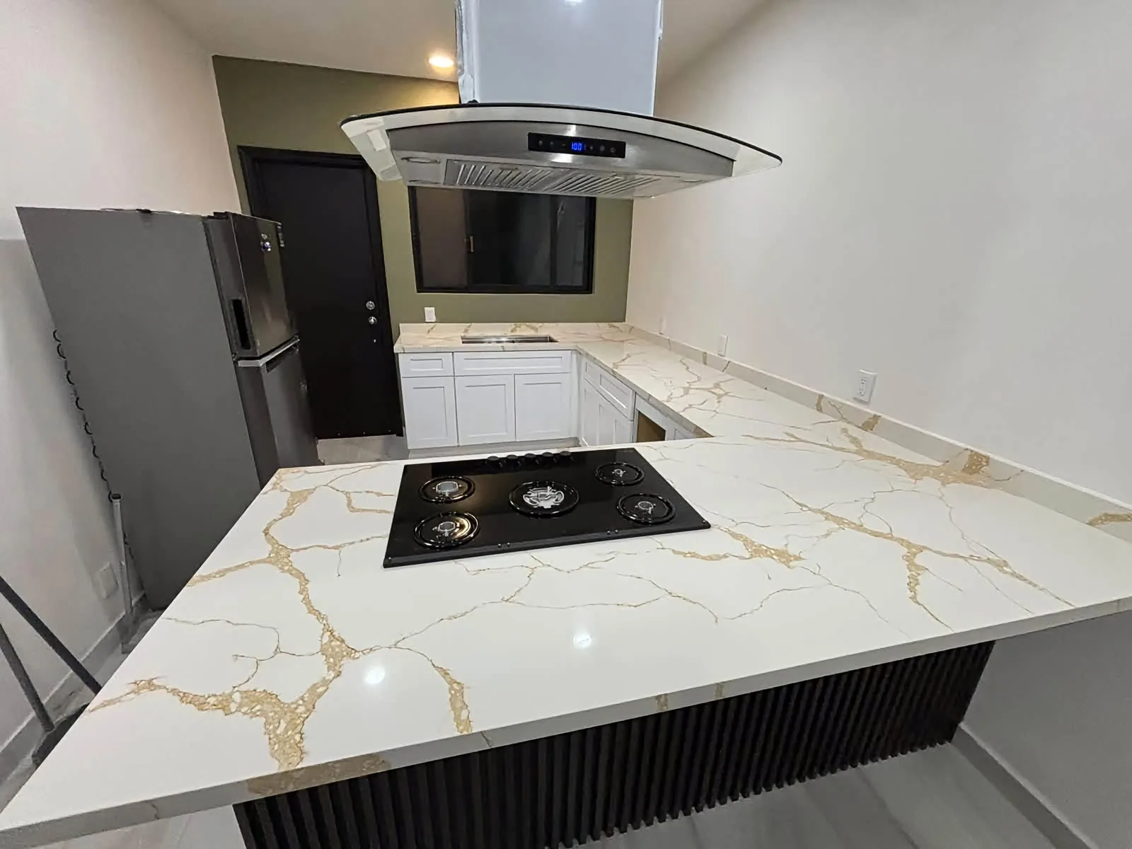 Cocina terminada con cubierta blanca de vetas doradas