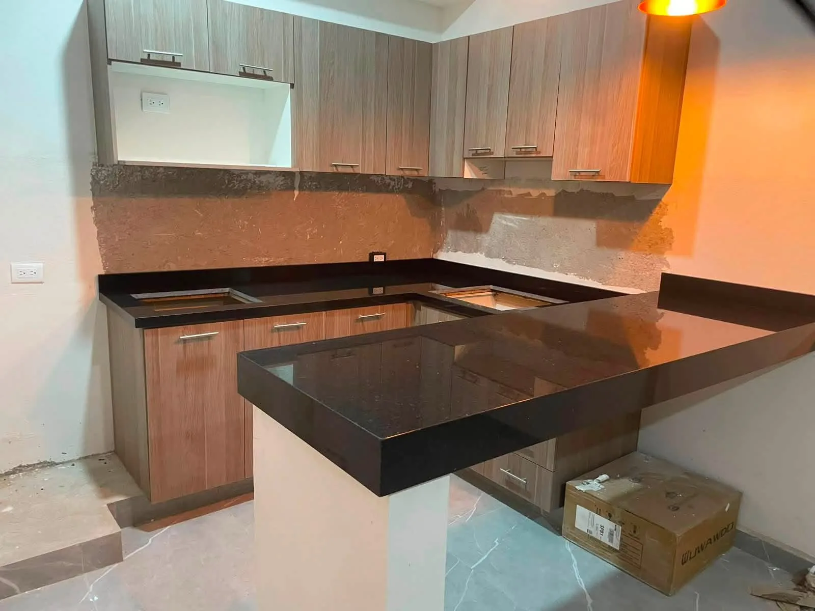 Cocina con cubierta negra en forma de L y barra